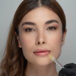 Woman receiving a cosmetic lip injection by a professional in a clinical setting.